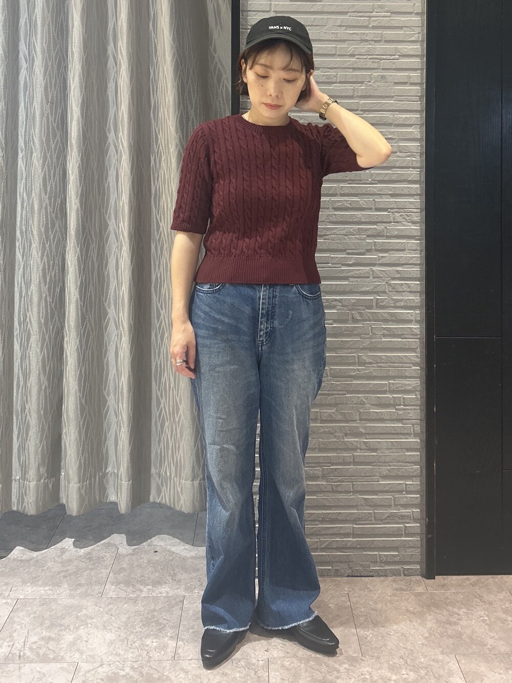 レッド系のニット/セーター、ブルー系のデニムパンツ、ブラック系のパンプスを着用したレディースの秋コーディネートの9枚目の写真