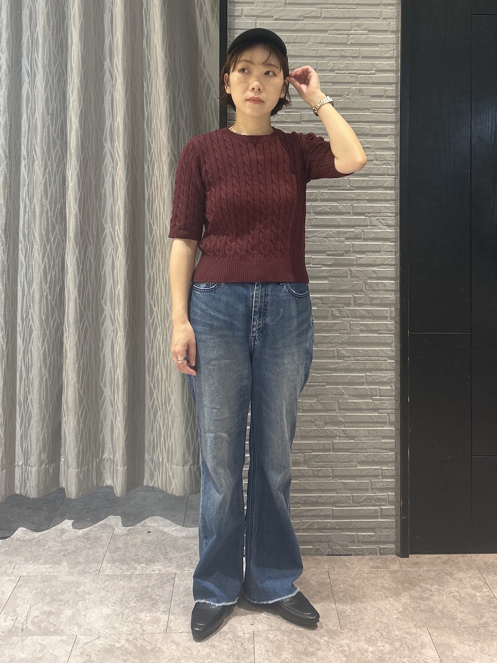 レッド系のニット/セーター、ブルー系のデニムパンツ、ブラック系のパンプスを着用したレディースの秋コーディネートの2枚目の写真