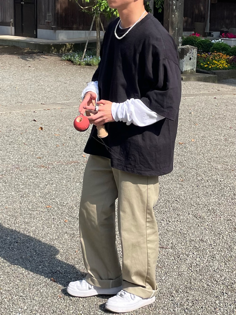 ブラック系のTシャツ/カットソー、ホワイト系のTシャツ/カットソー、ベージュ系のチノパンツを着用したメンズの春コーディネートの3枚目の写真