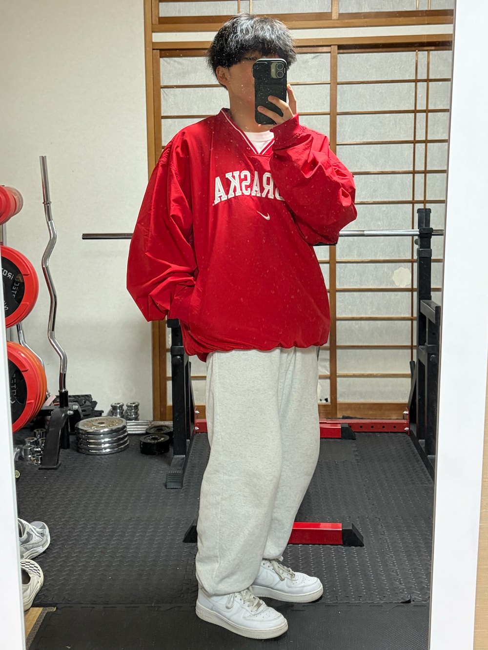 ホワイト系のスニーカー、レッド系のジャージ、ホワイト系のスウェットパンツを着用したメンズの秋コーディネートの2枚目の写真