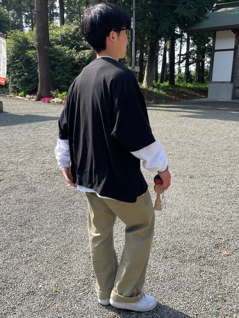 ブラック系のTシャツ/カットソー、ホワイト系のTシャツ/カットソー、ベージュ系のチノパンツを着用したメンズの春コーディネートの5枚目の写真