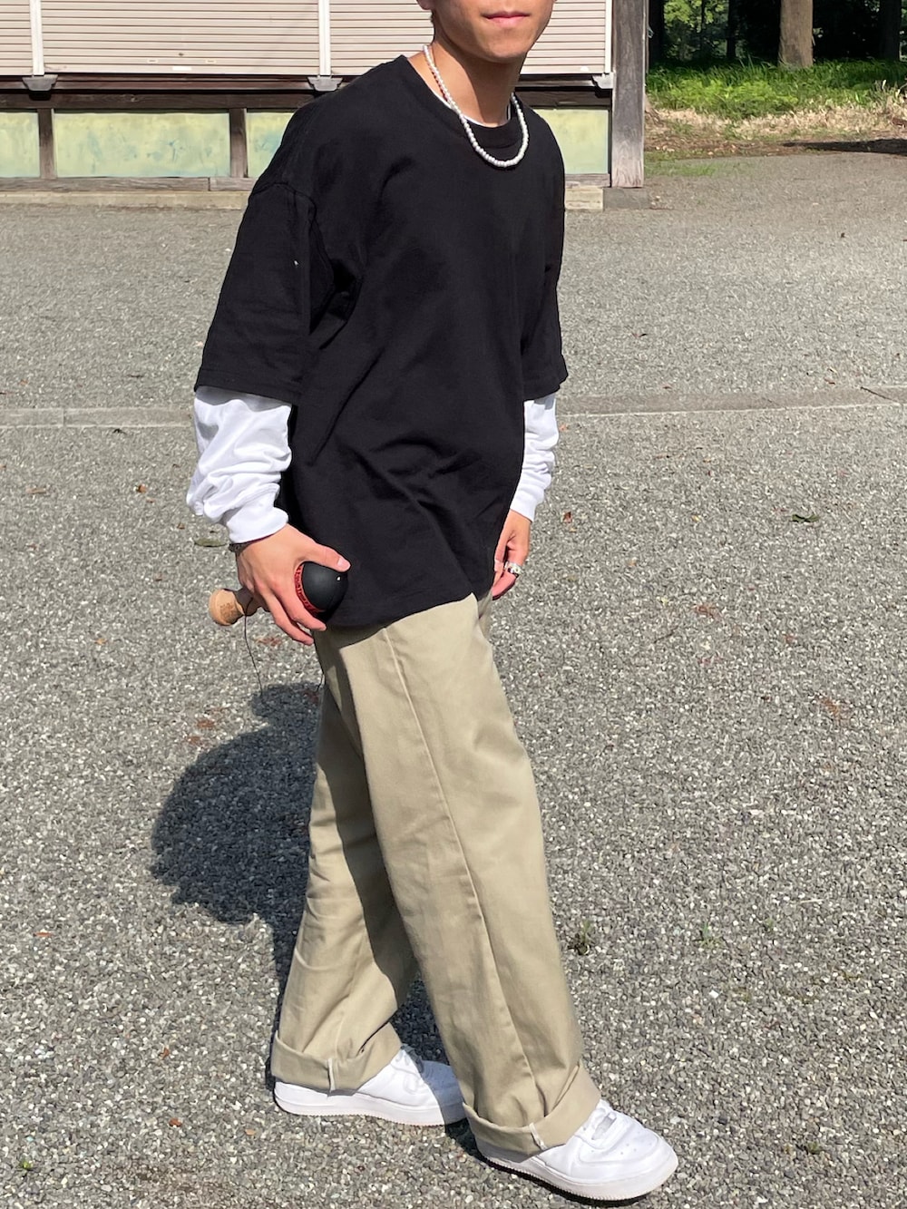 ブラック系のTシャツ/カットソー、ホワイト系のTシャツ/カットソー、ベージュ系のチノパンツを着用したメンズの春コーディネートの4枚目の写真