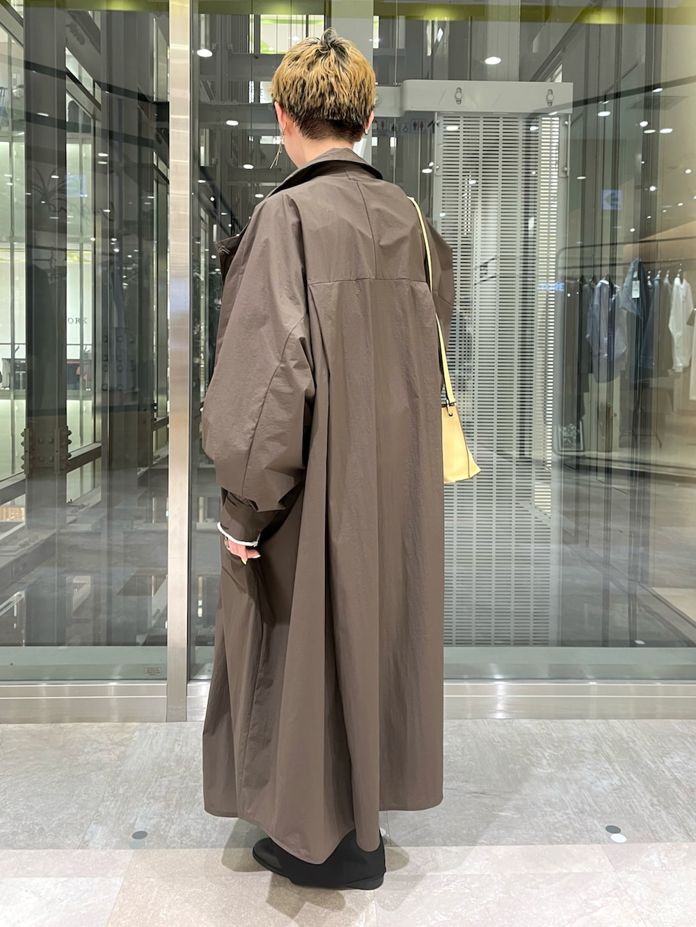 ブラウン系のトレンチコート、グレー系のTシャツ/カットソー、グレー系のトップスを着用したレディースの冬コーディネートの2枚目の写真