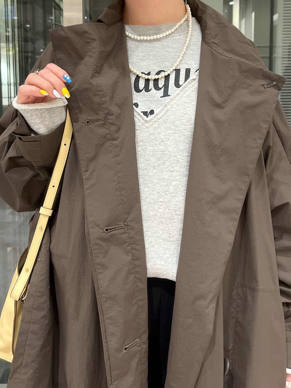 ブラウン系のトレンチコート、グレー系のTシャツ/カットソー、グレー系のトップスを着用したレディースの冬コーディネートの3枚目の写真