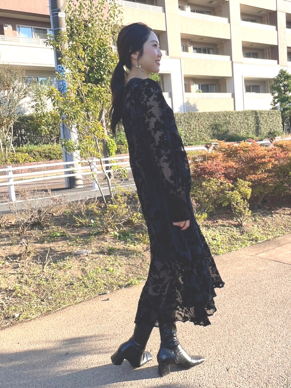 ブラック系のブーツ、ブラック系のワンピースを着用したレディースの秋コーディネートの2枚目の写真