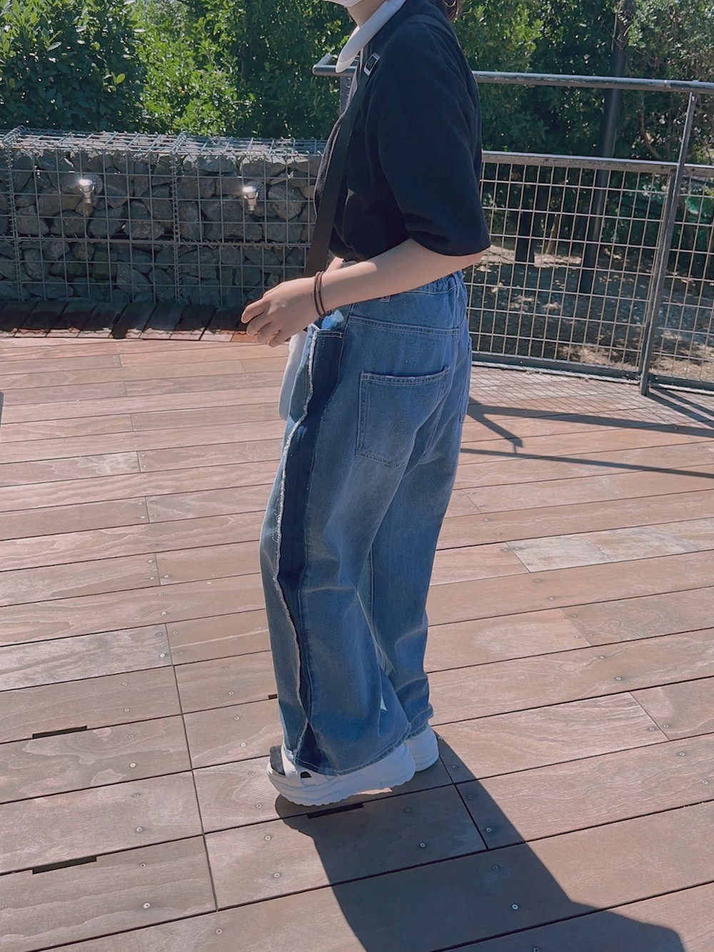 ブルー系のデニムパンツ、ブラック系のTシャツ/カットソー、ホワイト系のサンダルを着用したキッズの夏コーディネートの2枚目の写真