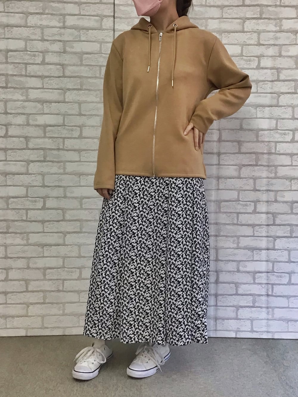 ベージュ系のパーカー、ブラック系のスカートを着用したレディースの秋コーディネートの2枚目の写真