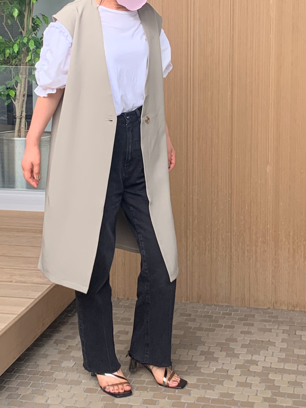 グリーン系のベスト、ホワイト系のTシャツ/カットソー、ブラック系のパンツを着用したレディースの夏コーディネートの2枚目の写真