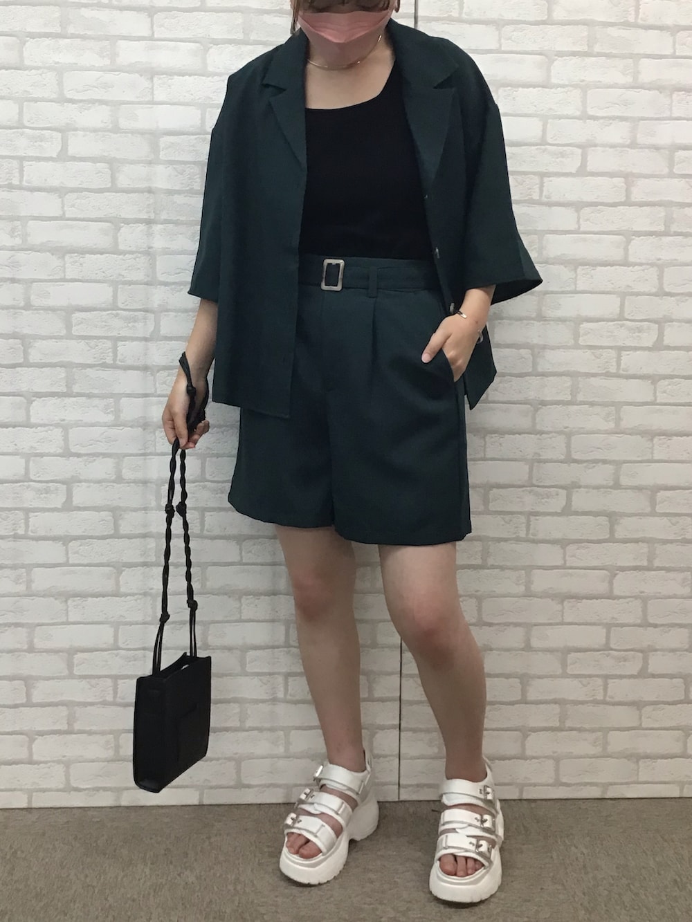 グリーン系のセットアップ、ブラック系のタンクトップ、ホワイト系のサンダルを着用したレディースの夏コーディネートの2枚目の写真