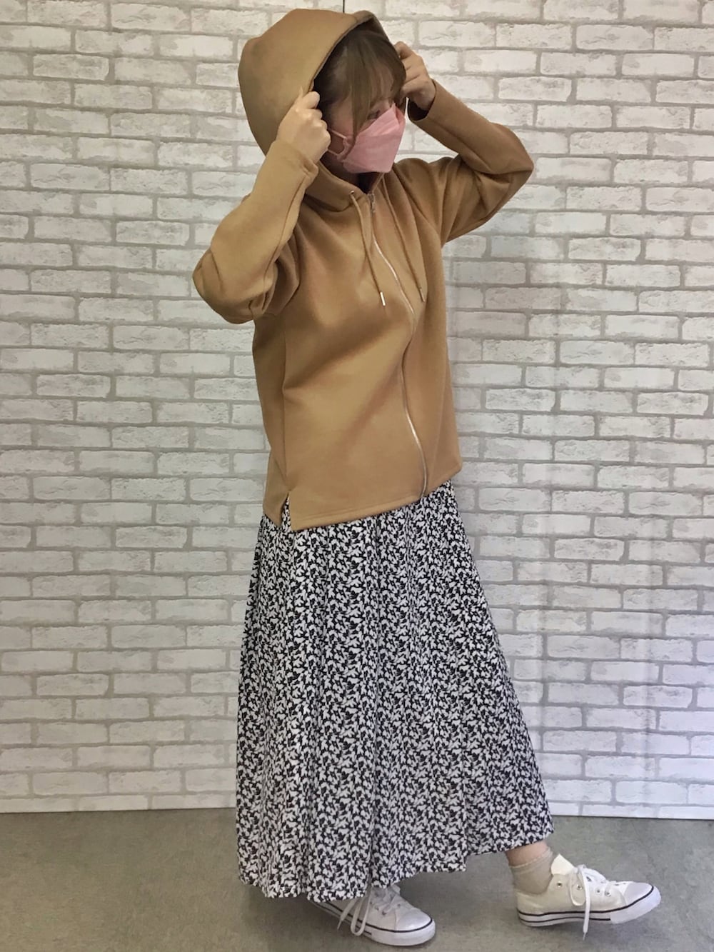 ベージュ系のパーカー、ブラック系のスカートを着用したレディースの秋コーディネートの3枚目の写真