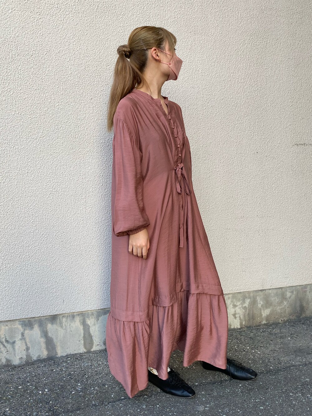 ピンク系のワンピースを着用したレディースの秋コーディネートの2枚目の写真