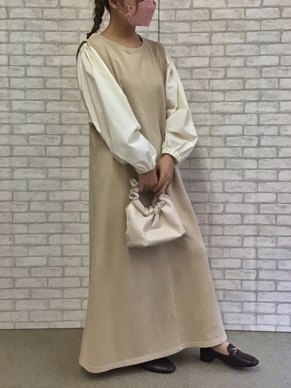 ベージュ系のワンピースを着用したレディースの秋コーディネートの2枚目の写真