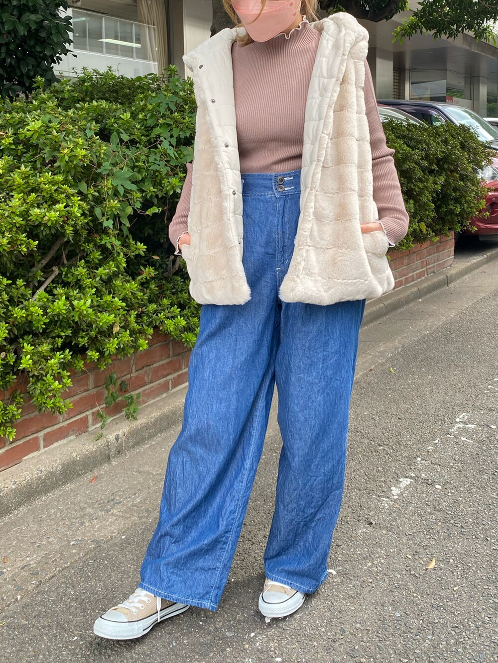 ブラウン系のニット/セーター、ブルー系のデニムパンツ、ベージュ系のベストを着用したレディースの秋コーディネートの2枚目の写真