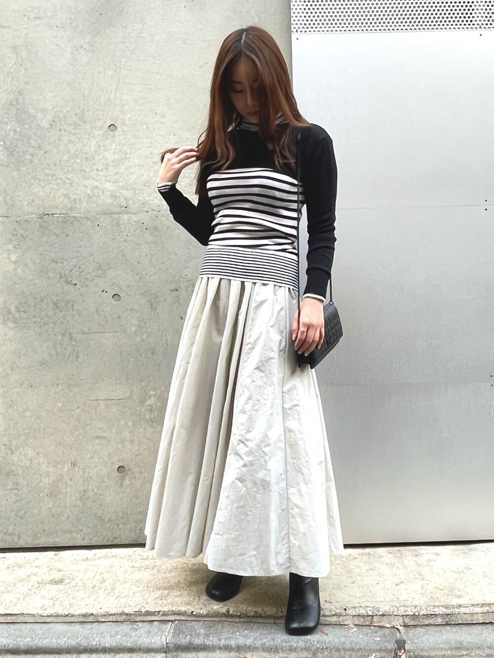 ブラック系のニット/セーター、ホワイト系のニット/セーター、グレー系のスカートを着用したレディースの冬コーディネートの3枚目の写真