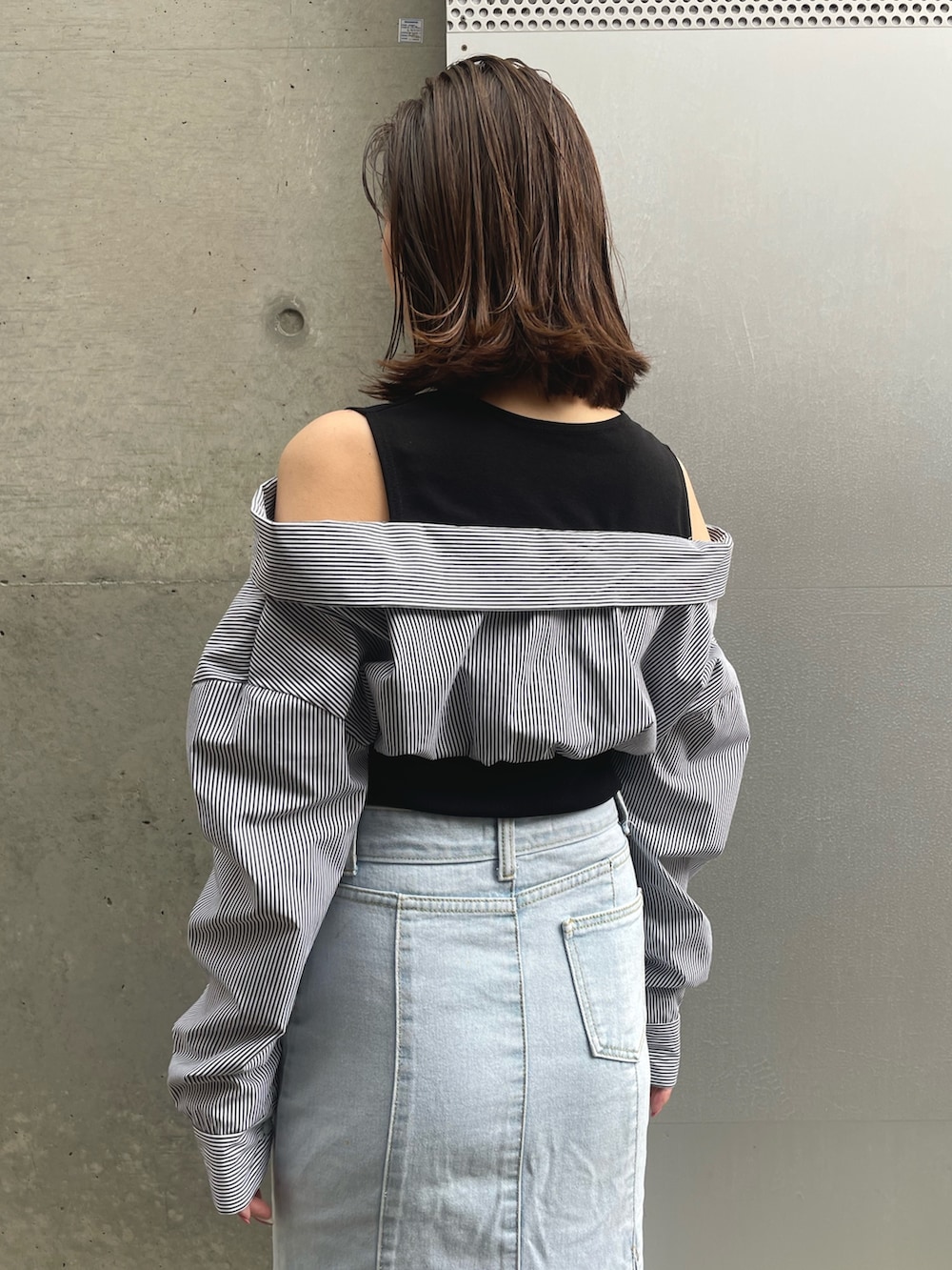 ブラック系のTシャツ/カットソー、ブルー系のデニムスカート、ブラック系のスニーカーを着用したレディースの春コーディネートの3枚目の写真