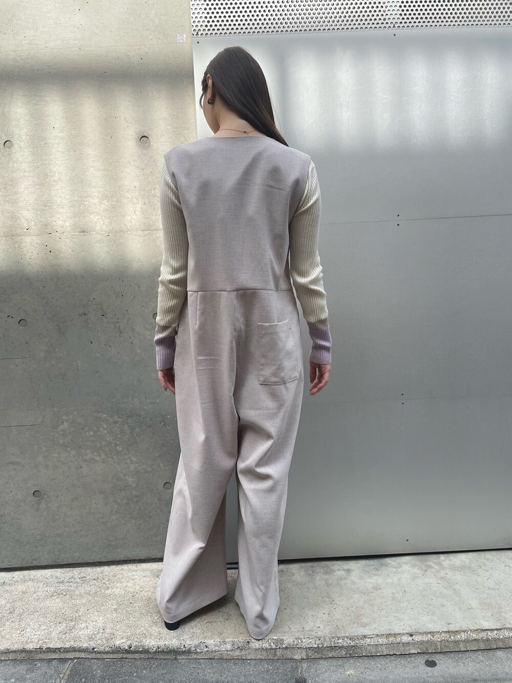 ブラック系のパンプス、ホワイト系のニット/セーター、ベージュ系のワンピースを着用したレディースの春コーディネートの3枚目の写真