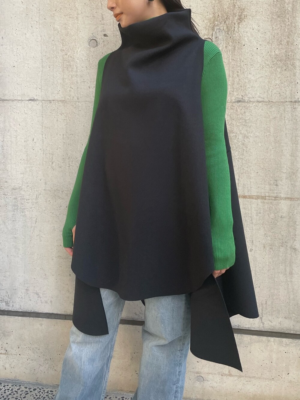 ブラック系のベスト、グリーン系のニット/セーターを着用したレディースの冬コーディネートの5枚目の写真