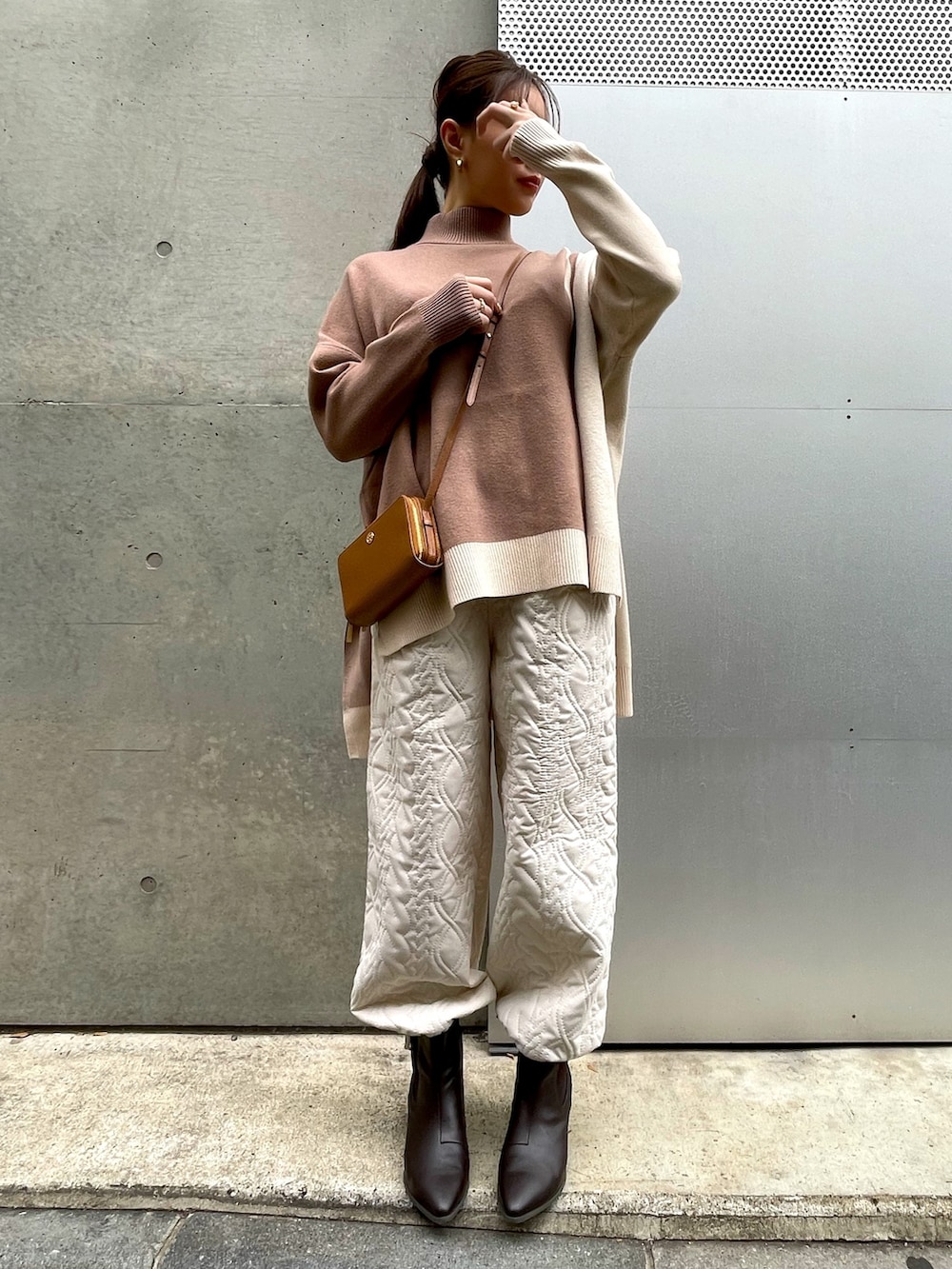 ブラウン系のショルダーバッグ、ベージュ系のニット/セーター、ホワイト系のその他パンツを着用したレディースの冬コーディネートの5枚目の写真