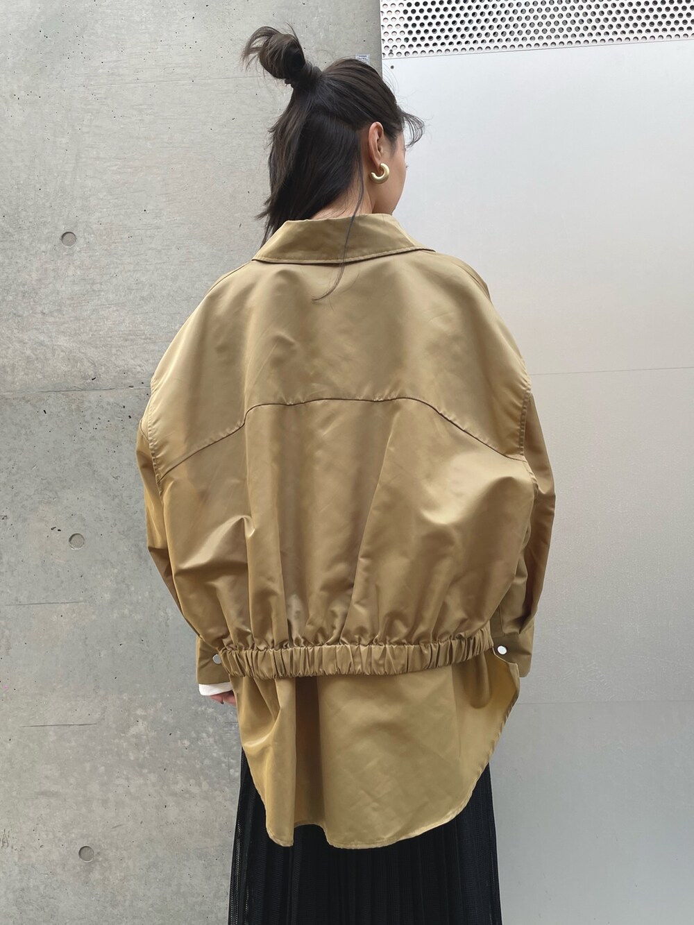 ベージュ系のブルゾン、ブラック系のスカートを着用したレディースの春コーディネートの3枚目の写真