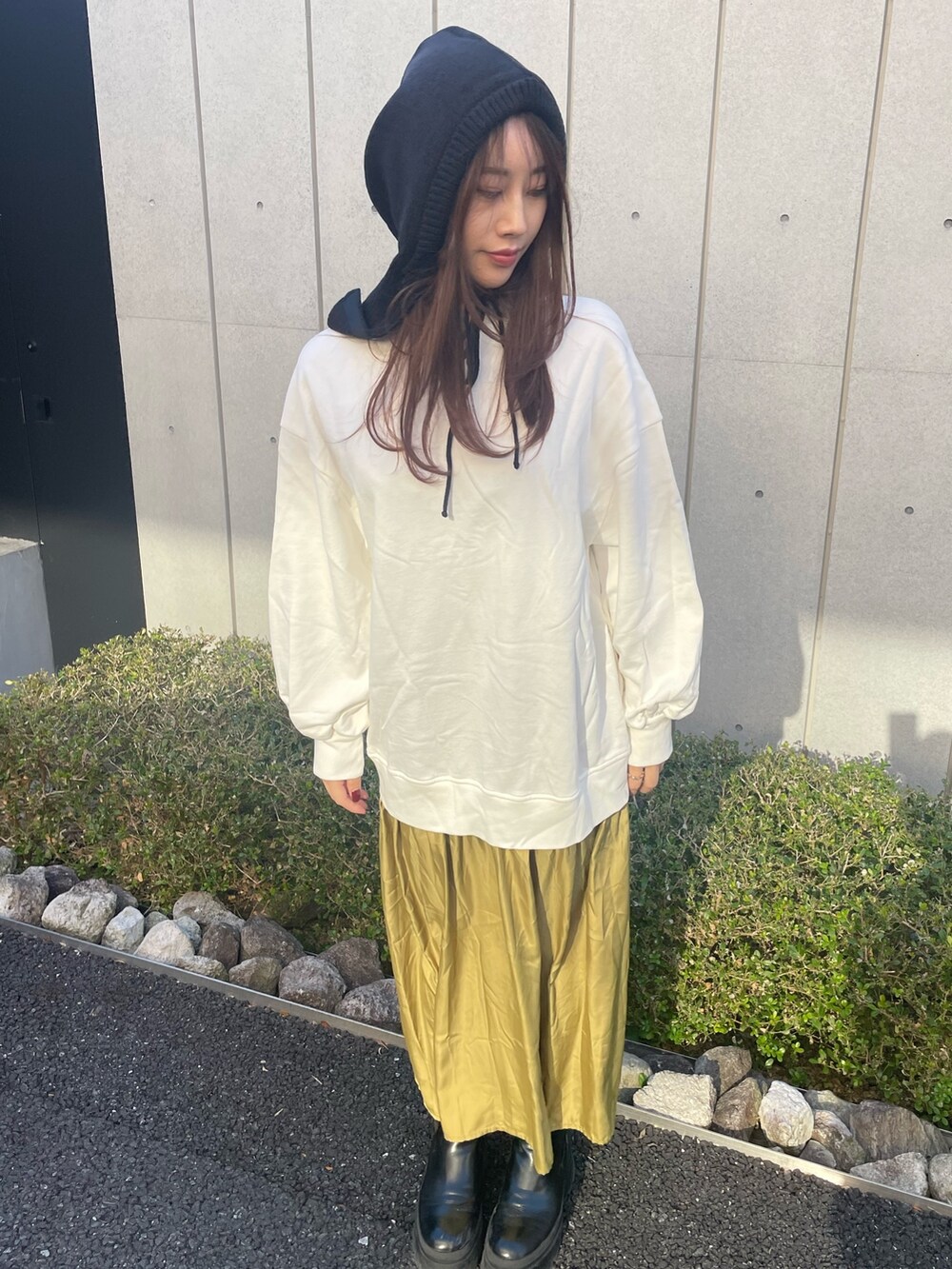 ホワイト系のワンピース、ブラック系のニットキャップ/ビーニーを着用したレディースの冬コーディネートの2枚目の写真