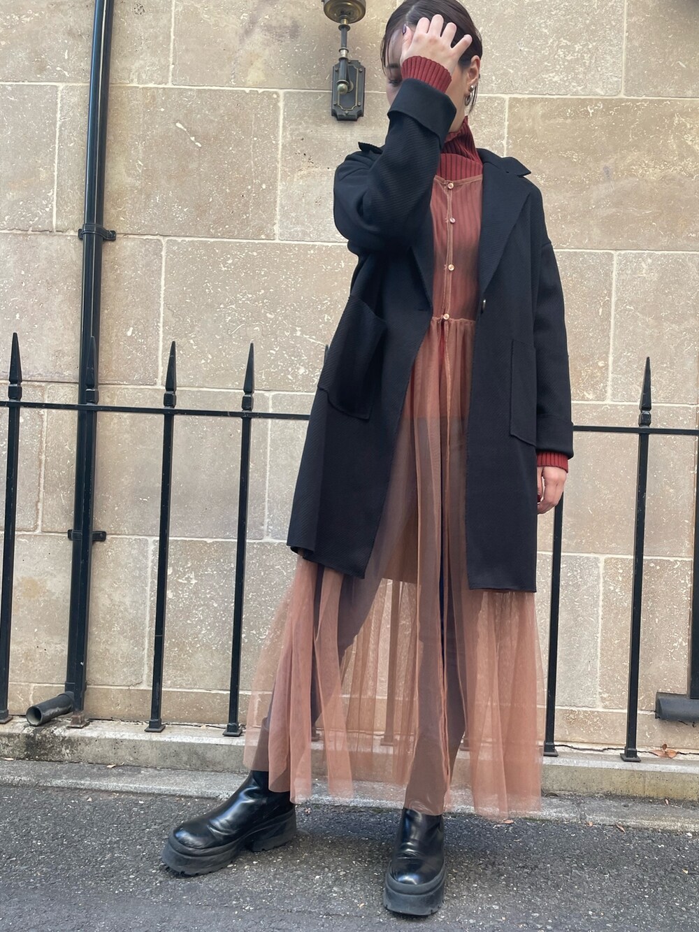 ベージュ系のワンピース、レッド系のニット/セーター、ブラック系のその他アウターを着用したレディースの秋コーディネートの5枚目の写真