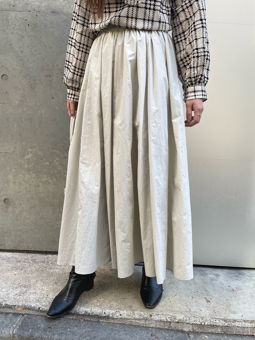 ホワイト系のハンドバッグ、グレー系のスカート、ホワイト系のシャツ/ブラウスを着用したレディースの冬コーディネートの4枚目の写真