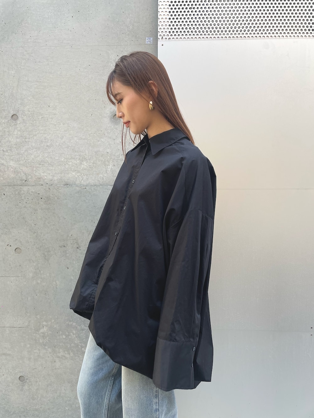 ブルー系のデニムパンツ、ブラック系のシャツ/ブラウスを着用したレディースの春コーディネートの3枚目の写真