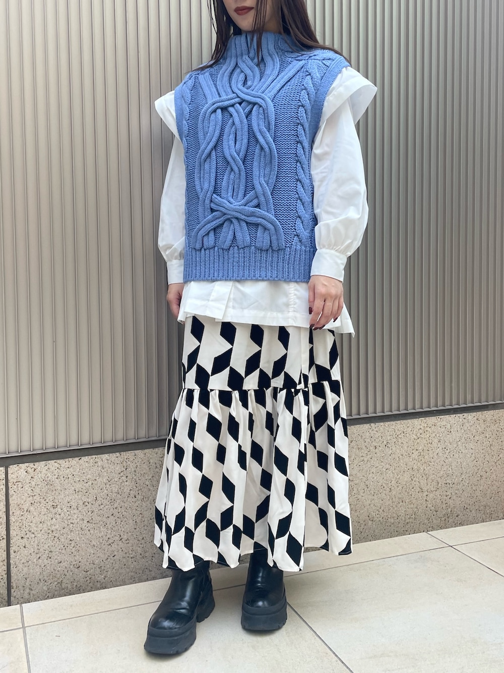 ブラック系のスカート、ブルー系のベスト、ホワイト系のシャツ/ブラウスを着用したレディースの冬コーディネートの4枚目の写真