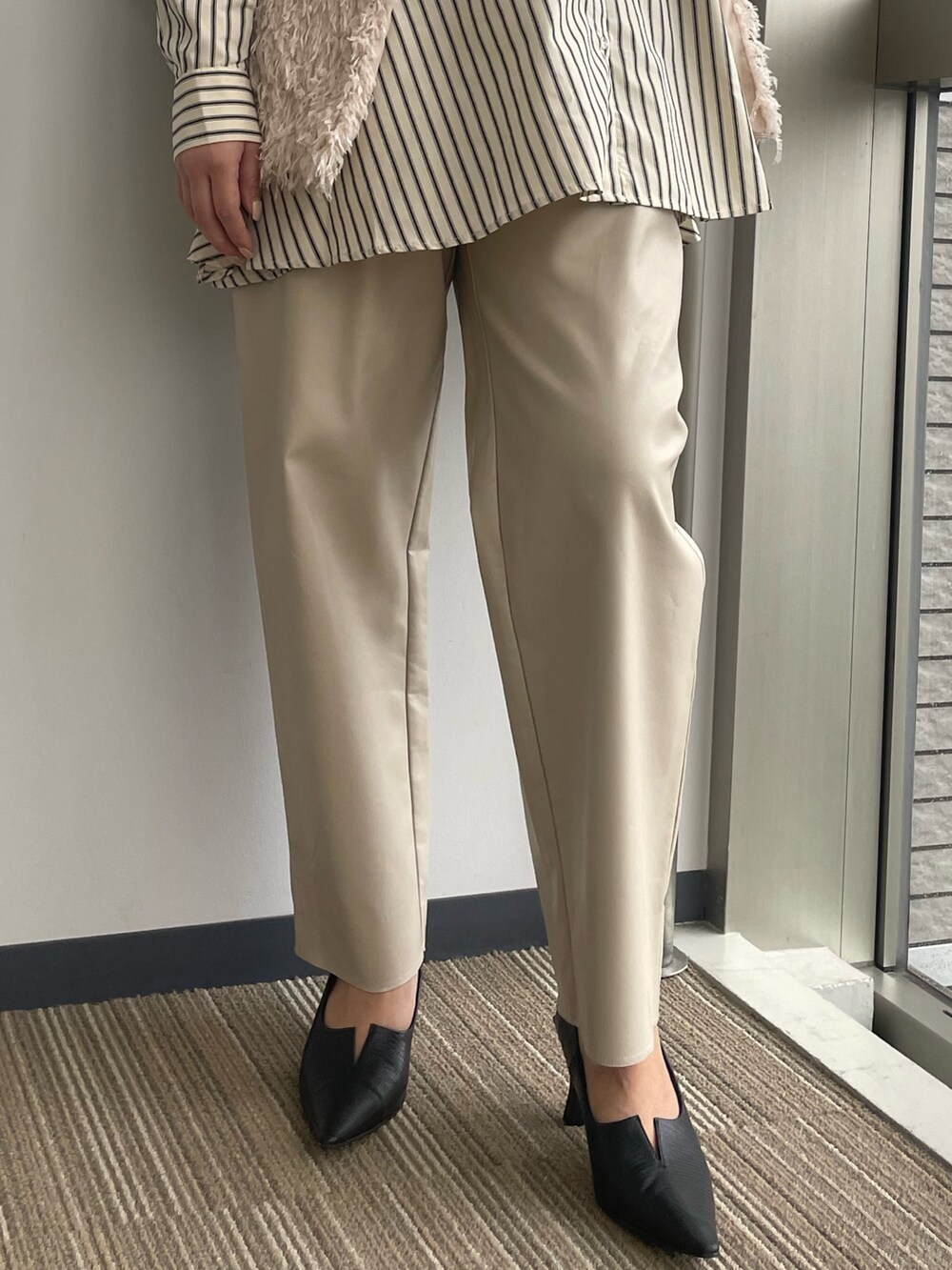 ベージュ系のベストを着用したレディースの冬コーディネートの10枚目の写真