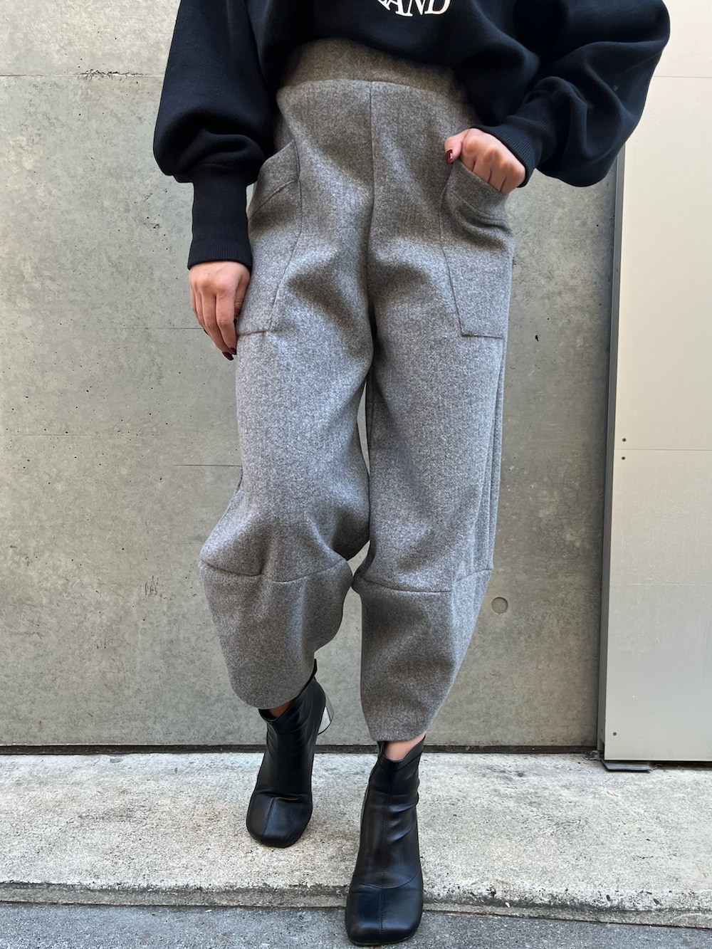 グレー系のその他パンツ、ブラック系のニット/セーター、ブラック系のハットを着用したレディースの冬コーディネートの7枚目の写真