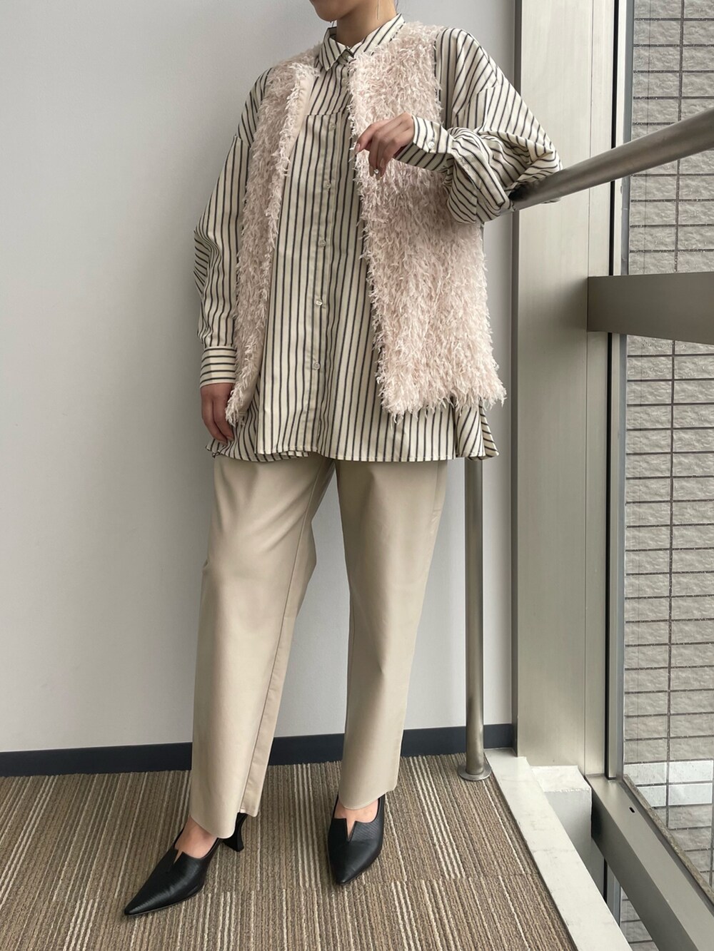 ベージュ系のベストを着用したレディースの冬コーディネートの2枚目の写真