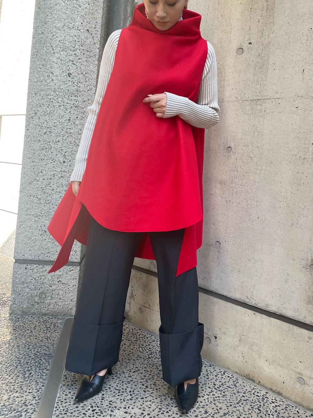 レッド系のベスト、ホワイト系のニット/セーター、ブラック系のその他パンツを着用したレディースの秋コーディネートの2枚目の写真