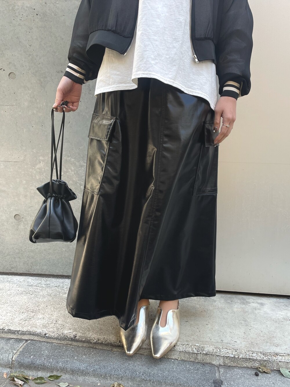 ブラック系のブルゾン、ブラック系のショルダーバッグ、ブラック系のスカートを着用したレディースの春コーディネートの5枚目の写真
