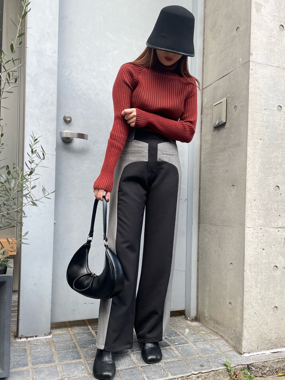 ブラック系のその他パンツ、ブラック系のショルダーバッグ、レッド系のニット/セーターを着用したレディースの冬コーディネートの6枚目の写真