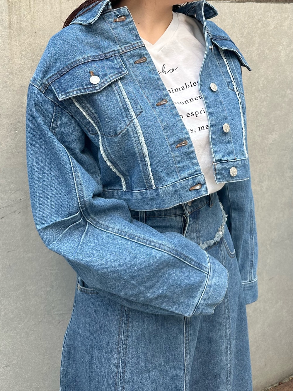 ブルー系のデニムジャケット、ブルー系のスカート、ホワイト系のスニーカーを着用したレディースの春コーディネートの3枚目の写真