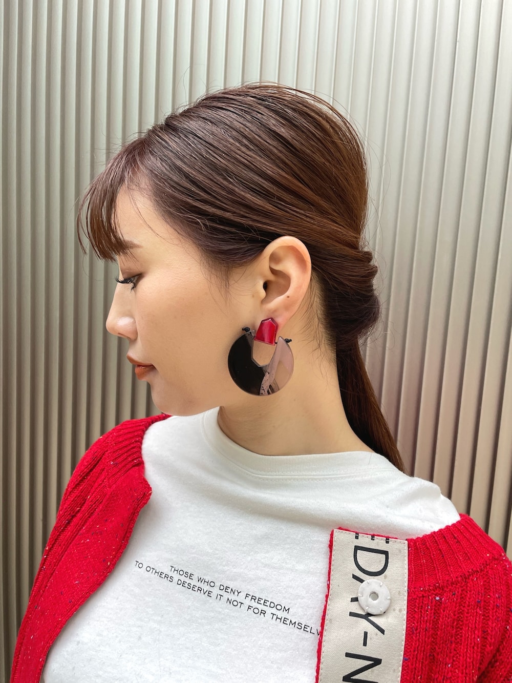 ブラック系のバッグ、ブラック系のスカート、レッド系のカーディガン/ボレロを着用したレディースの冬コーディネートの4枚目の写真