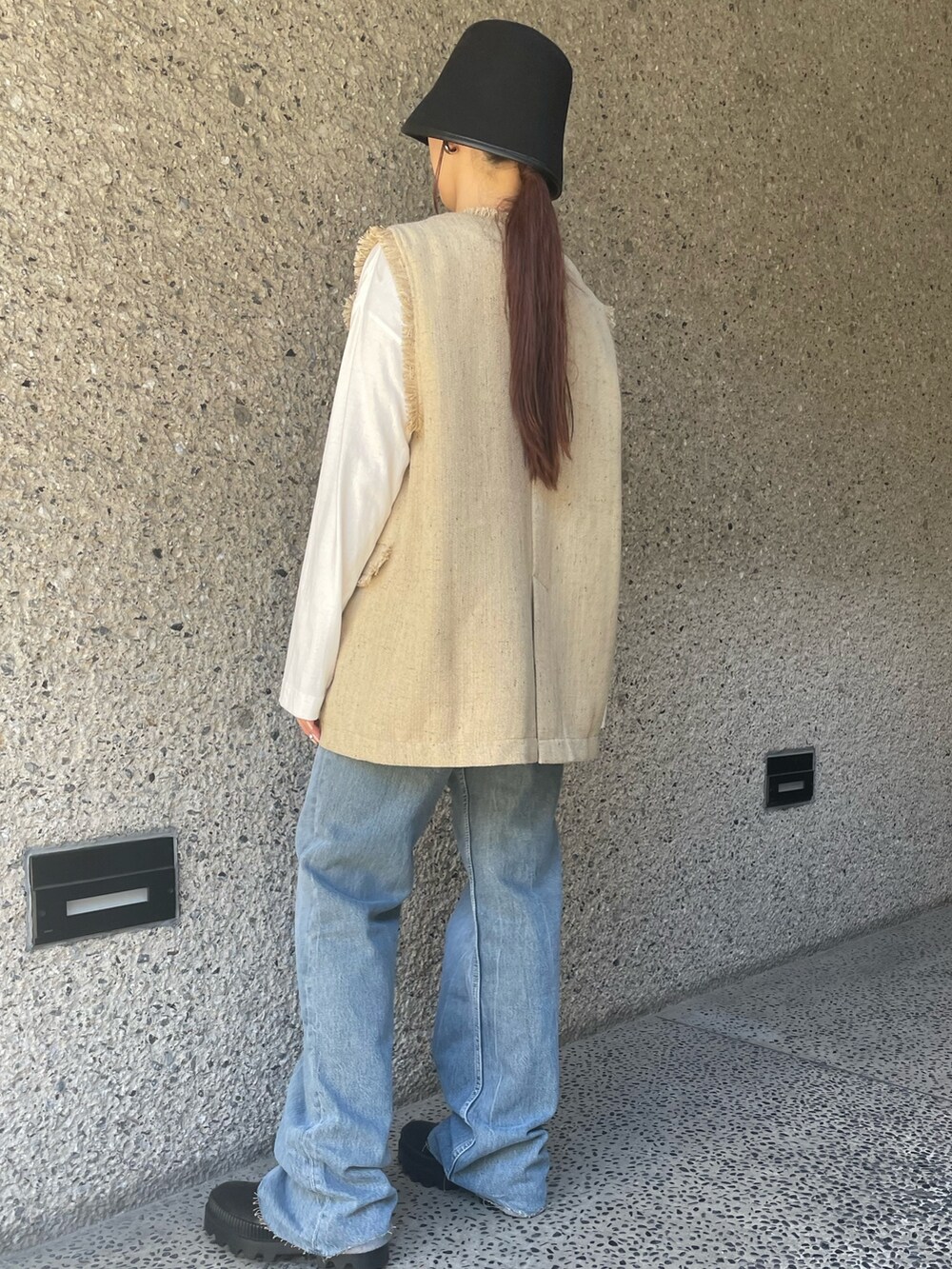 ベージュ系のベスト、ブラック系のハットを着用したレディースの冬コーディネートの4枚目の写真