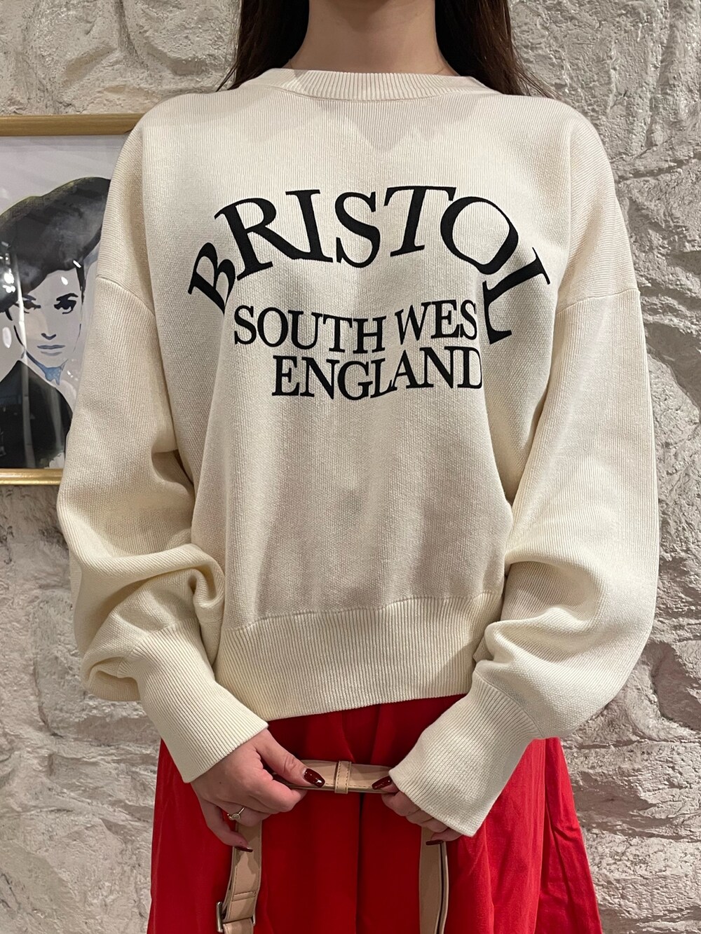 ホワイト系のニット/セーター、レッド系のスカートを着用したレディースの秋コーディネートの7枚目の写真