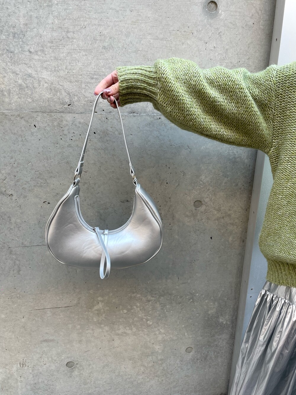 シルバー系のスカート、ホワイト系のスニーカー、ホワイト系のTシャツ/カットソーを着用したレディースの冬コーディネートの5枚目の写真