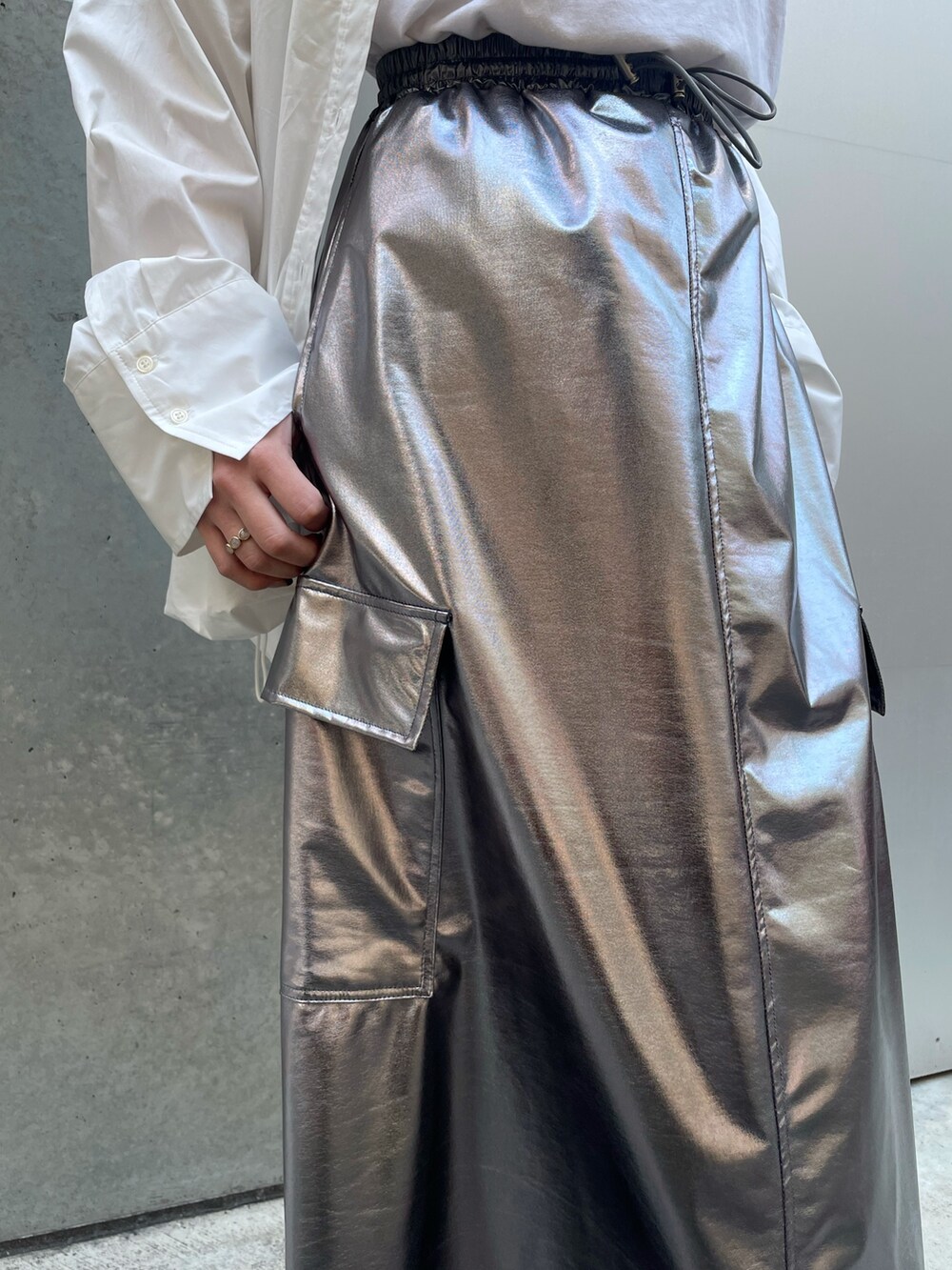 ホワイト系のハンドバッグ、ホワイト系のスニーカー、シルバー系のスカートを着用したレディースの春コーディネートの8枚目の写真