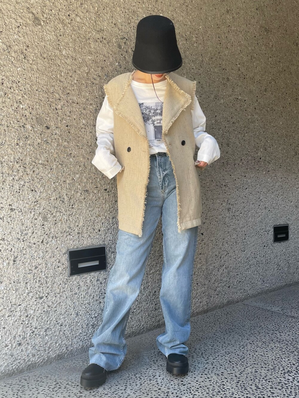 ベージュ系のベスト、ブラック系のハットを着用したレディースの冬コーディネートの5枚目の写真