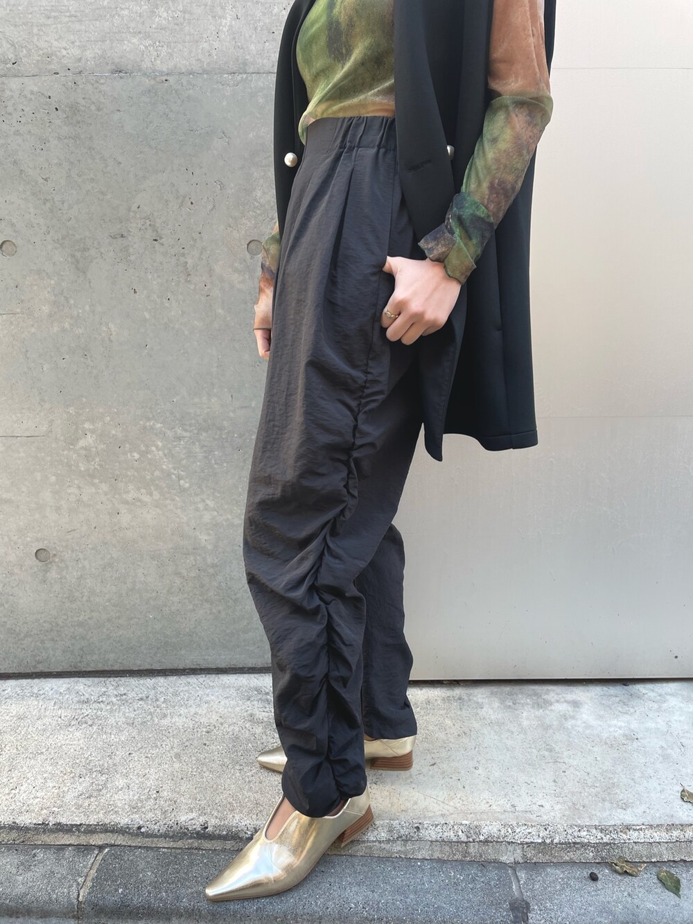 ブラック系のベスト、ブラック系のその他パンツ、グリーン系のTシャツ/カットソーを着用したレディースの春コーディネートの5枚目の写真