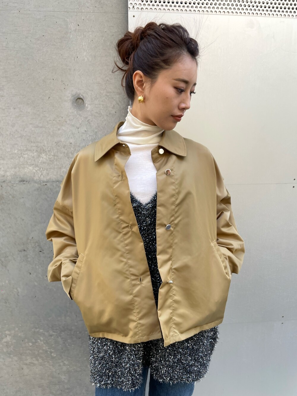 ブラック系のベスト、ベージュ系のブルゾン、ホワイト系のTシャツ/カットソーを着用したレディースの冬コーディネートの3枚目の写真