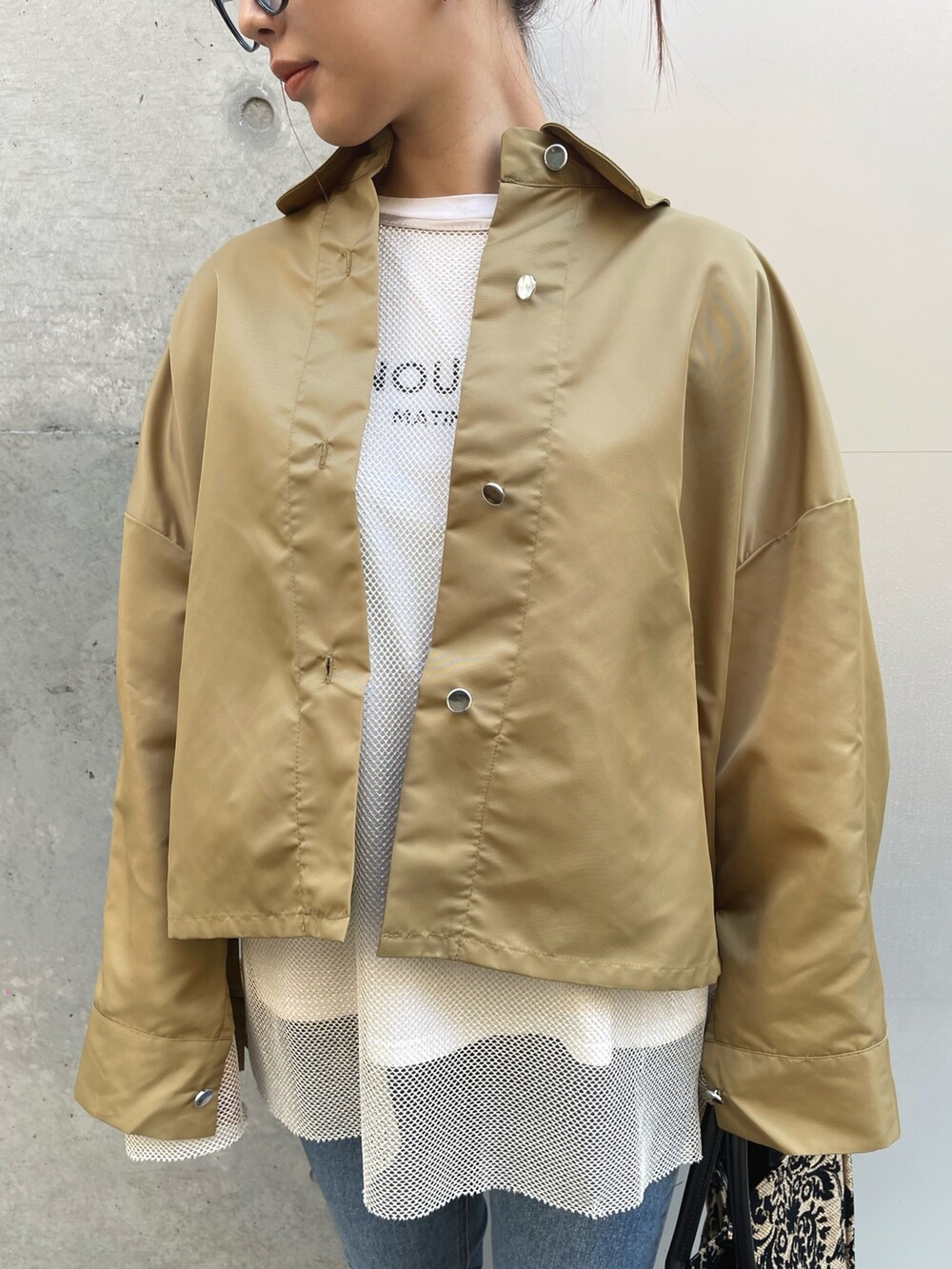 ホワイト系のTシャツ/カットソー、ブルー系のデニムパンツ、ブラック系のブーツを着用したレディースの冬コーディネートの3枚目の写真