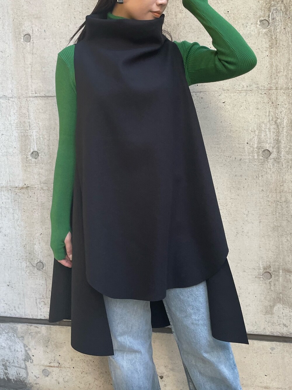 ブラック系のベスト、グリーン系のニット/セーターを着用したレディースの冬コーディネートの7枚目の写真