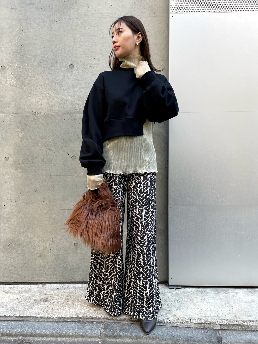 ブラウン系のハンドバッグ、ゴールド系のTシャツ/カットソー、ブラック系のその他パンツを着用したレディースの冬コーディネートの2枚目の写真