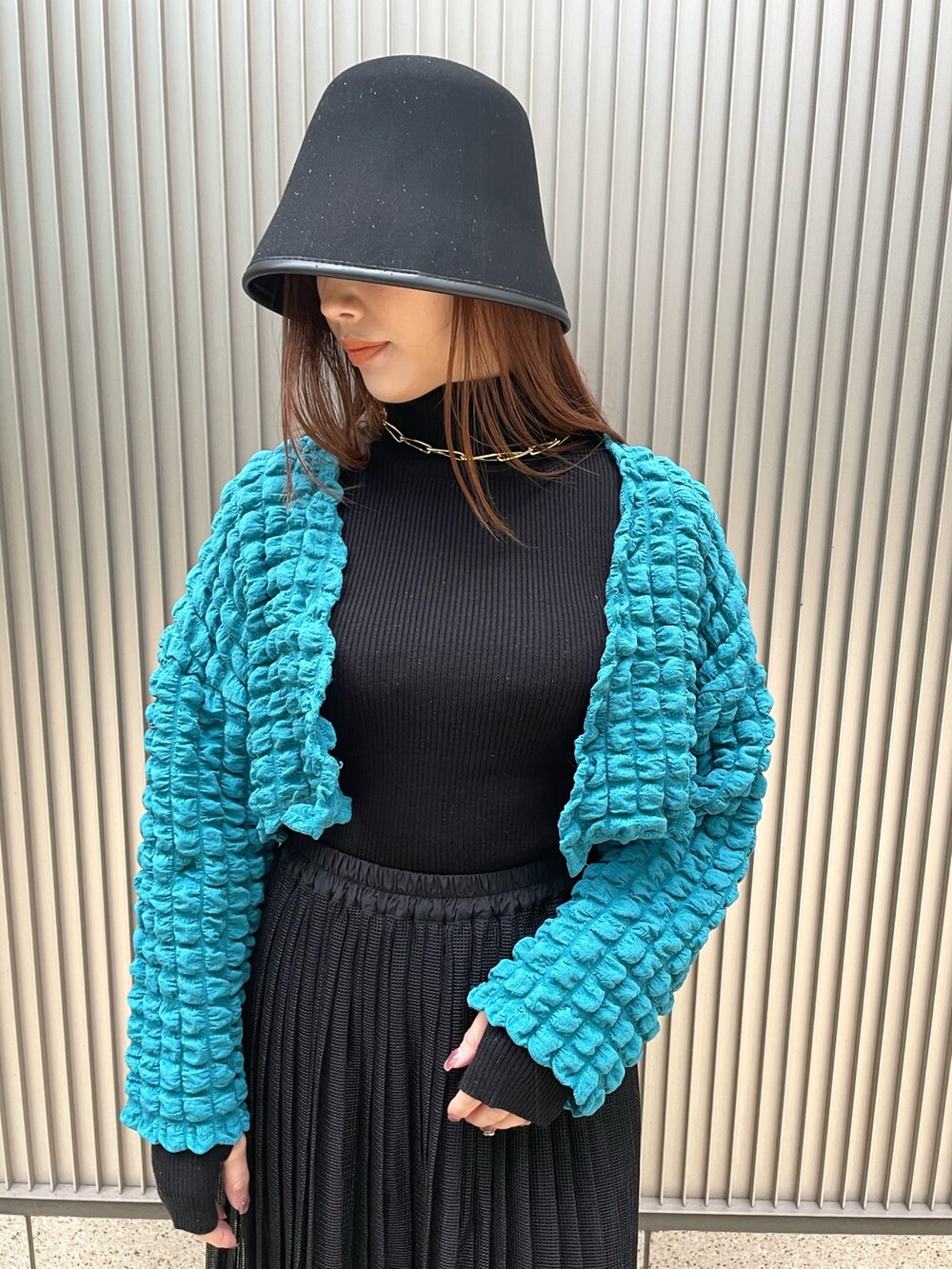 ブラック系のニット/セーター、ブルー系のカーディガン/ボレロ、ブラック系のスカートを着用したレディースの冬コーディネートの3枚目の写真