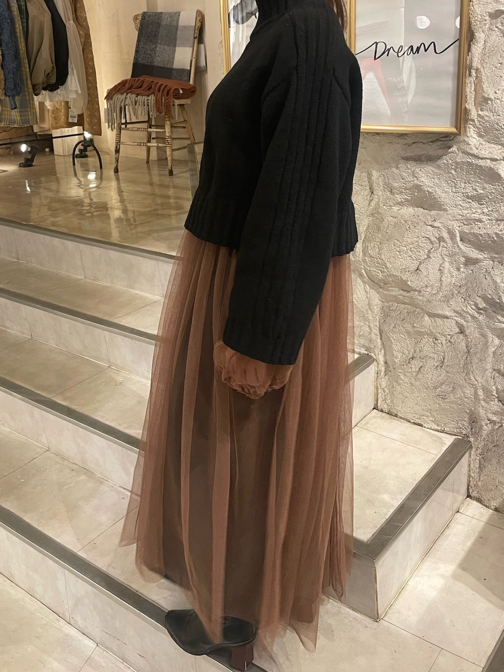 ベージュ系のワンピース、ブラック系のニット/セーターを着用したレディースの秋コーディネートの2枚目の写真