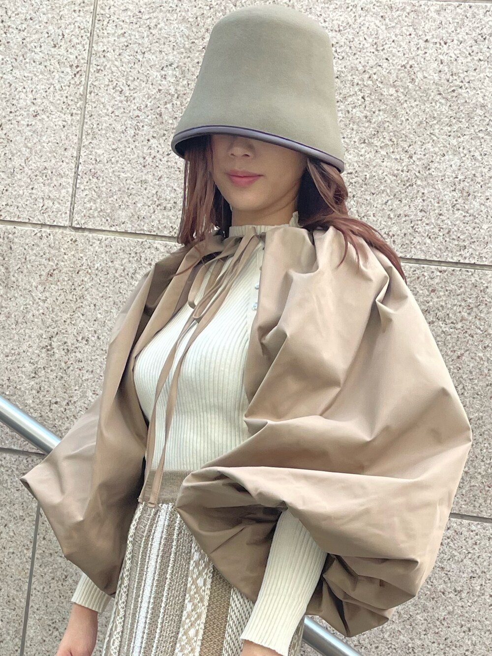 ベージュ系のスカート、ブラウン系のカーディガン/ボレロ、グリーン系のハットを着用したレディースの秋コーディネートの4枚目の写真