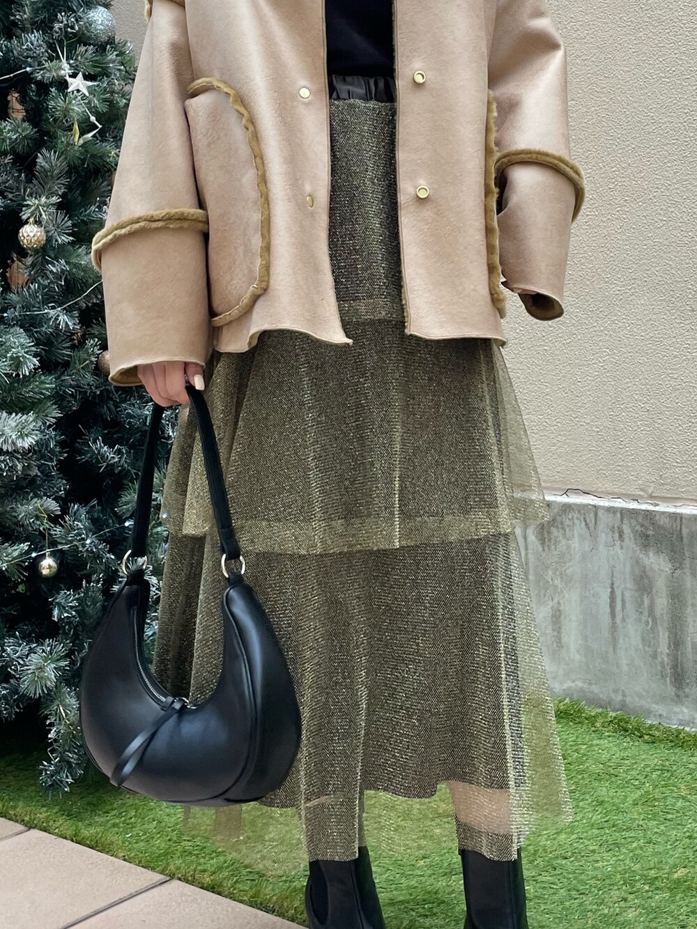 ゴールド系のスカート、ブラック系のショルダーバッグ、ブラック系のTシャツ/カットソーを着用したレディースの冬コーディネートの8枚目の写真